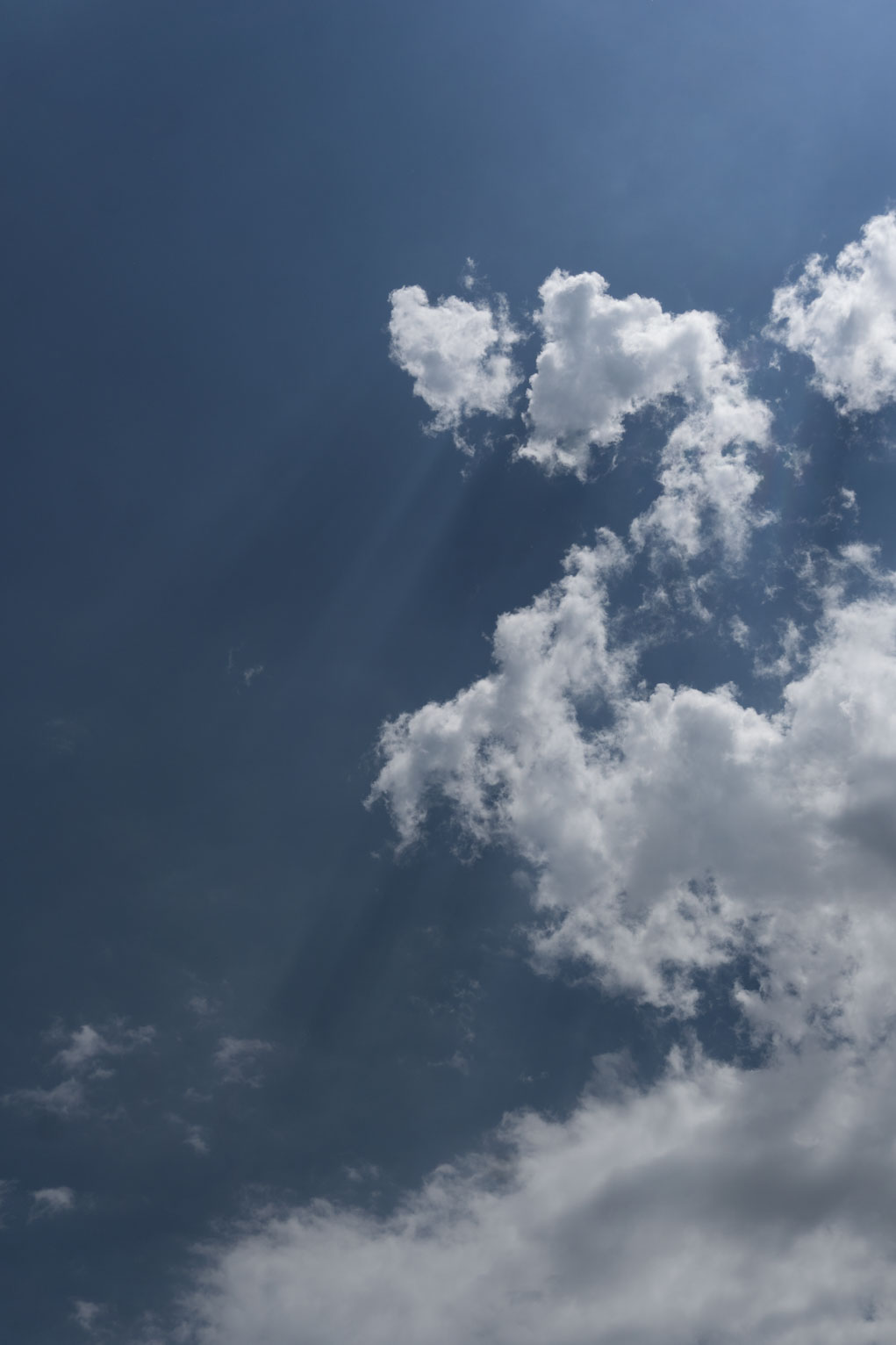 White clouds in the blue sky cast some shadows from the sun above